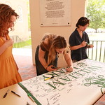 Graduating students sign their Class of 2024 banner.