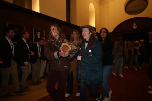 The yule logs are carried into the Great Hall.